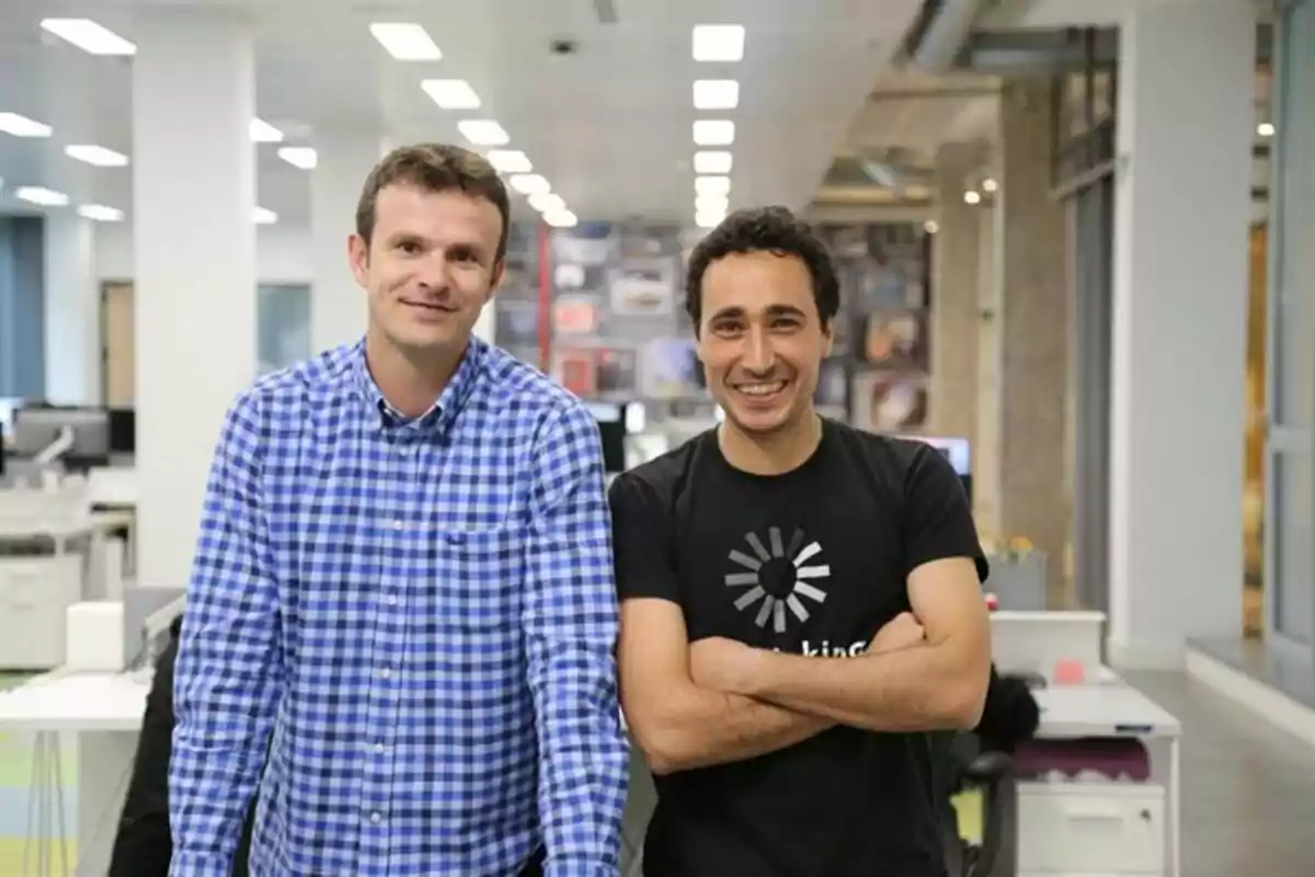 Dos hombres sonrientes posan juntos en una oficina moderna y luminosa Dos hombres sonrientes posan juntos en una oficina moderna y luminosa