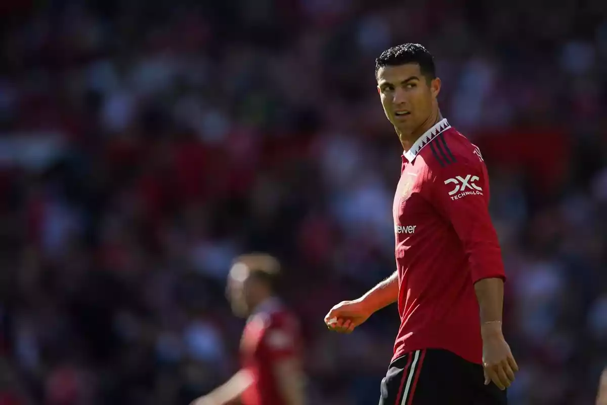 Jugador de fútbol con uniforme rojo en el campo durante un partido.