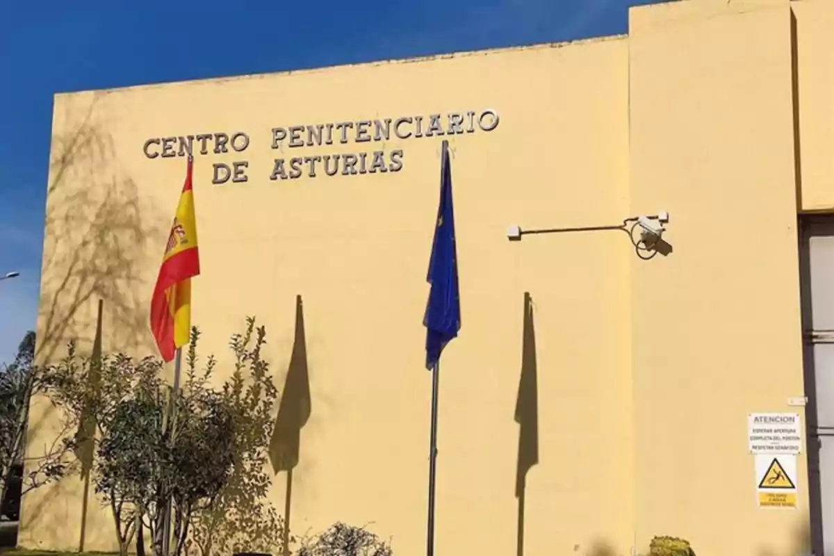 Fachada del Centro Penitenciario de Asturias con banderas de España y la Unión Europea ondeando.