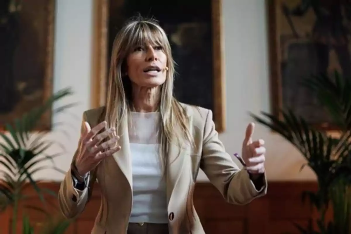 Una mujer hablando con gestos expresivos en un entorno interior con plantas y cuadros en la pared. Una mujer hablando con gestos expresivos en un entorno interior con plantas y cuadros en la pared.
