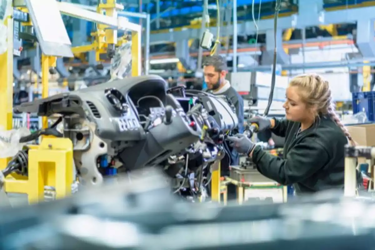 Trabajadores ensamblando componentes en una línea de producción automotriz. Trabajadores ensamblando componentes en una línea de producción automotriz.