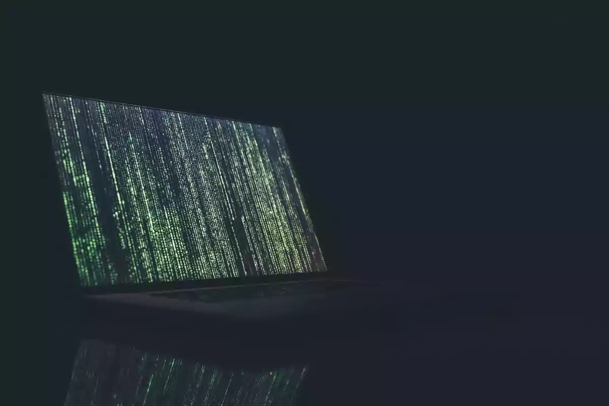 Pantalla de computadora portátil mostrando líneas de código verde en un fondo oscuro.