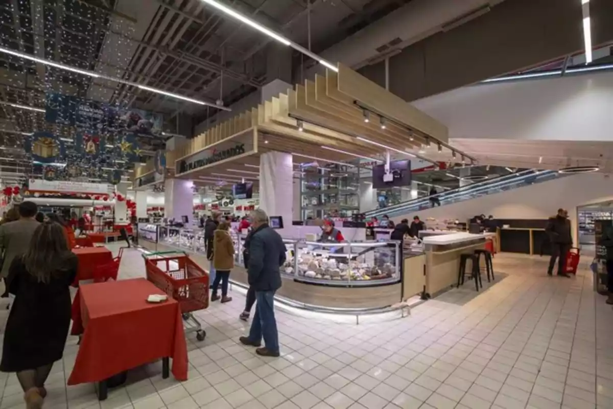Personas comprando en un supermercado decorado para la temporada navideña con luces y adornos festivos. Personas comprando en un supermercado decorado para la temporada navideña con luces y adornos festivos.