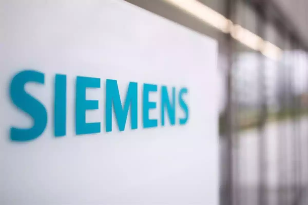 Logo de Siemens en una pared blanca dentro de un edificio moderno Logo de Siemens en una pared blanca dentro de un edificio moderno