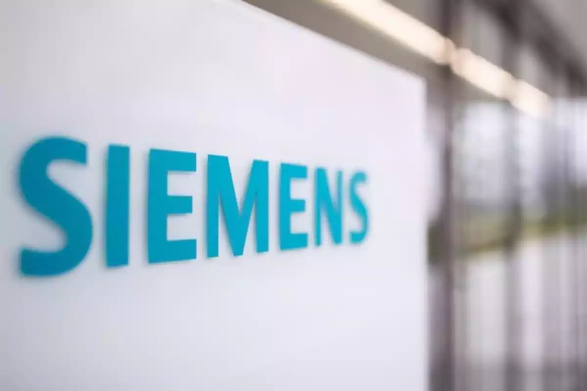 Un letrero con el logotipo de Siemens en un entorno moderno y desenfocado.