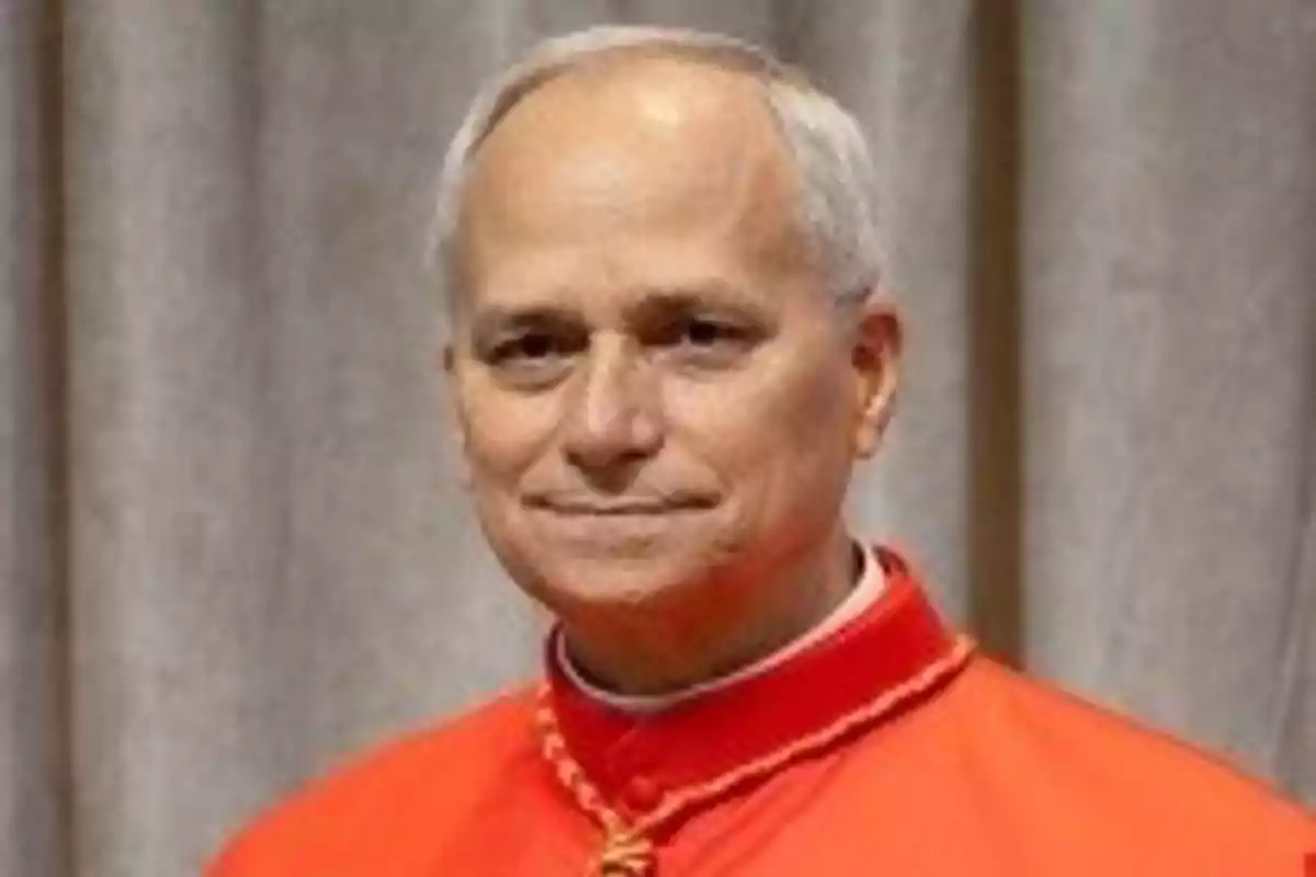 Un hombre con vestimenta religiosa roja frente a un fondo gris. Un hombre con vestimenta religiosa roja frente a un fondo gris.