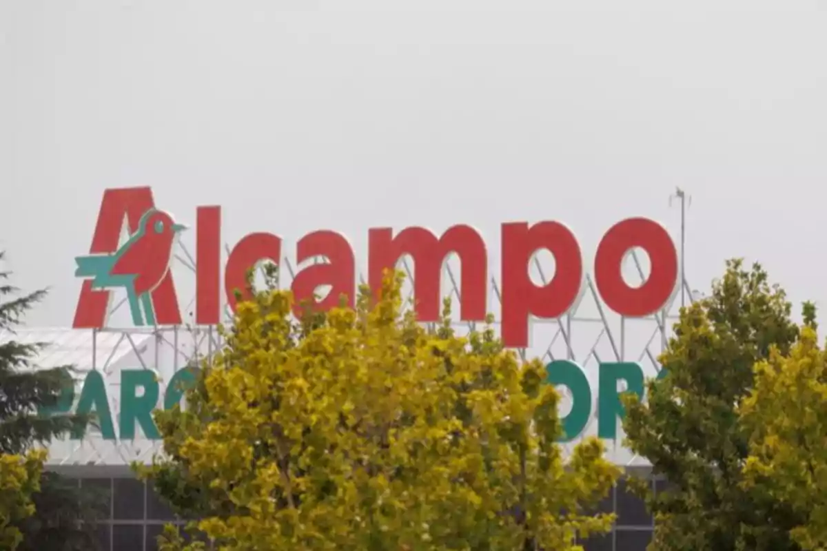 Un letrero de Alcampo detrás de unos árboles. Un letrero de Alcampo detrás de unos árboles.
