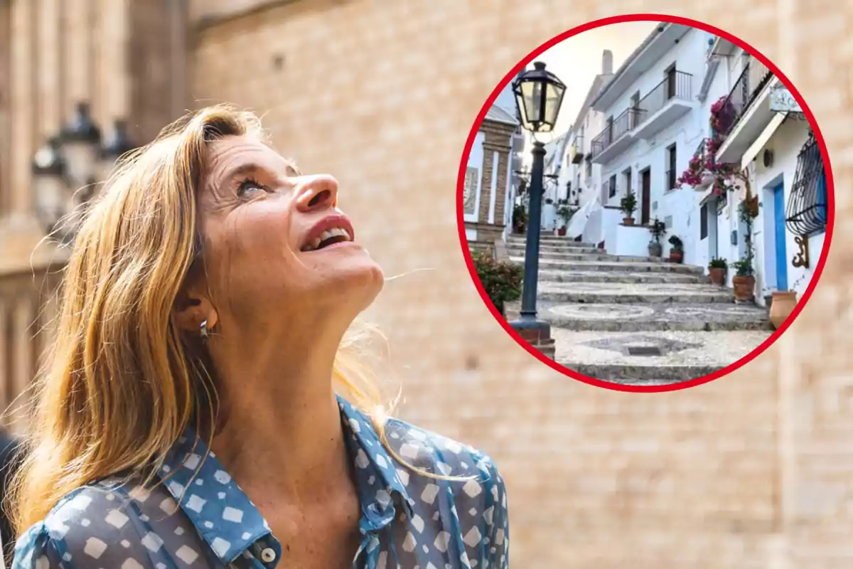 Una mujer sonriente mira hacia arriba con una imagen circular de una calle empedrada y casas blancas en el fondo.