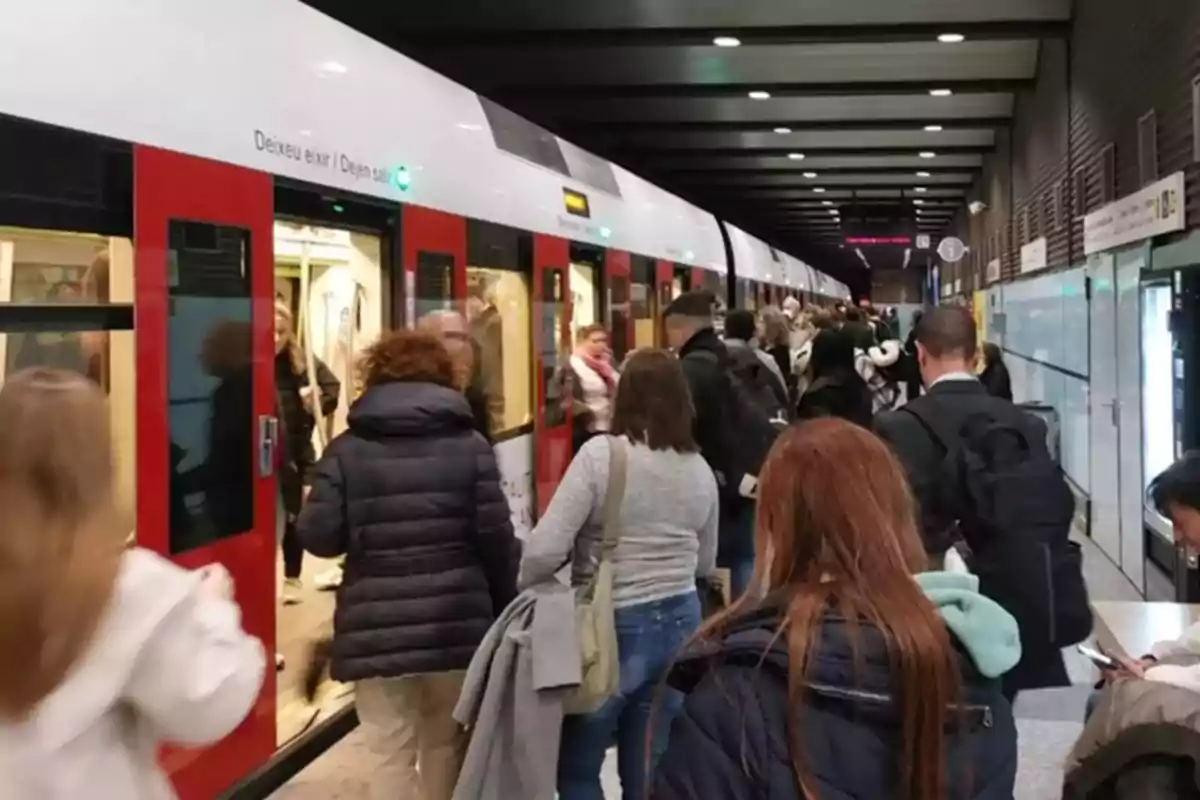 Personas subiendo y bajando de un tren en una estación concurrida.