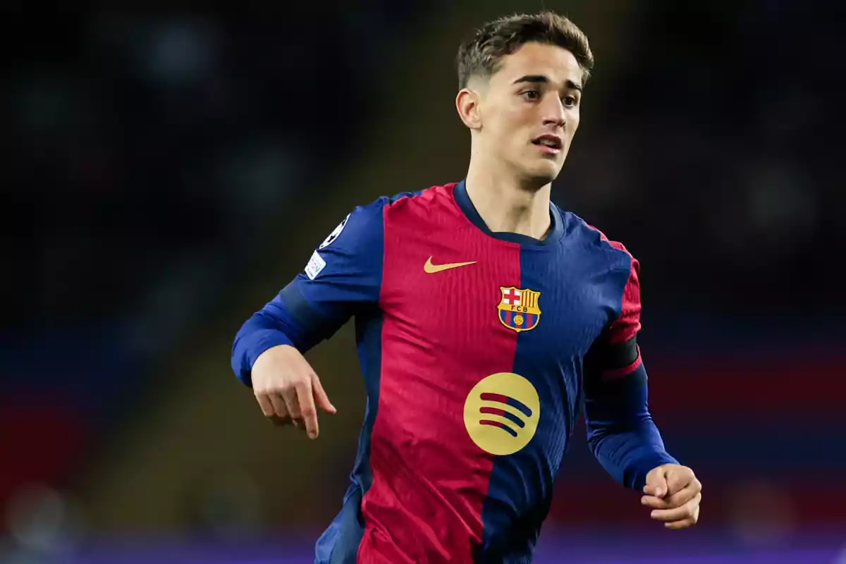 Jugador del FC Barcelona con uniforme azul y rojo durante un partido de fútbol Jugador del FC Barcelona con uniforme azul y rojo durante un partido de fútbol