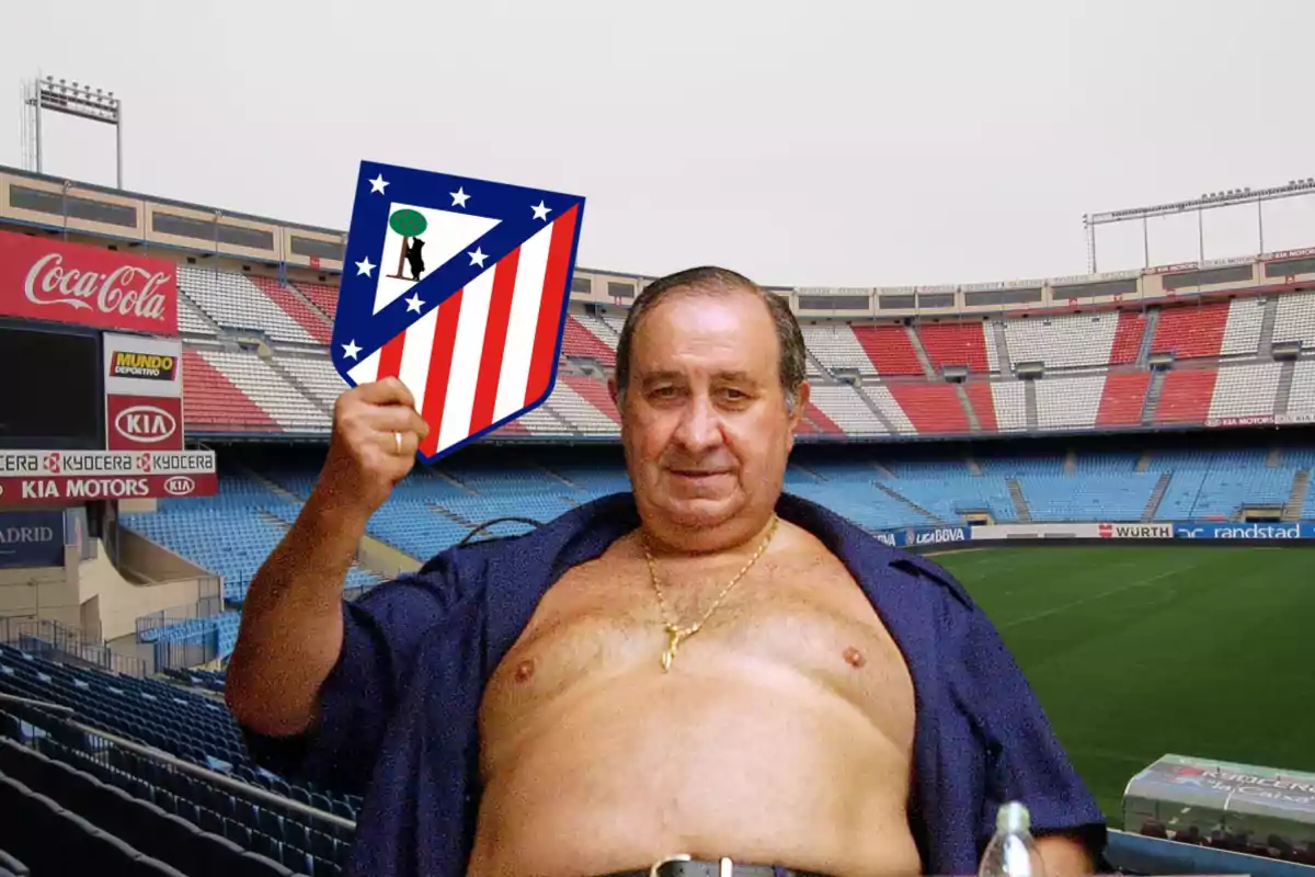 Hombre en un estadio sosteniendo un escudo del Atlético de Madrid.