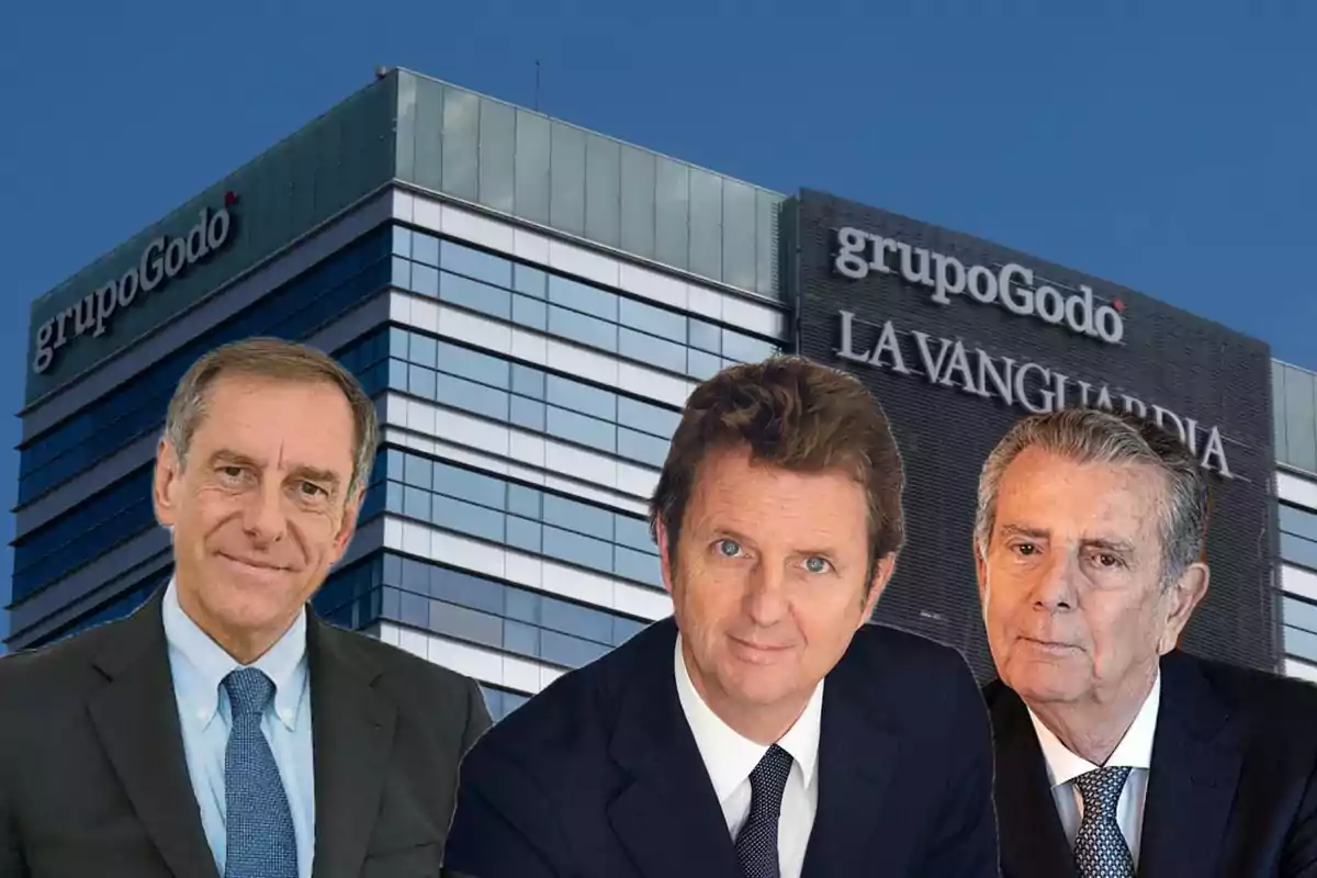 Tres hombres en traje frente a un edificio con los logotipos de "grupo Godó" y "La Vanguardia".