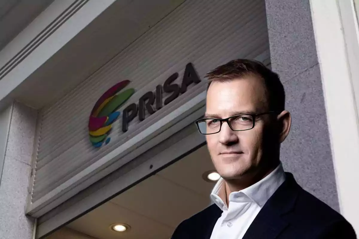Un hombre con gafas de pie frente a un edificio con el logo de PRISA.