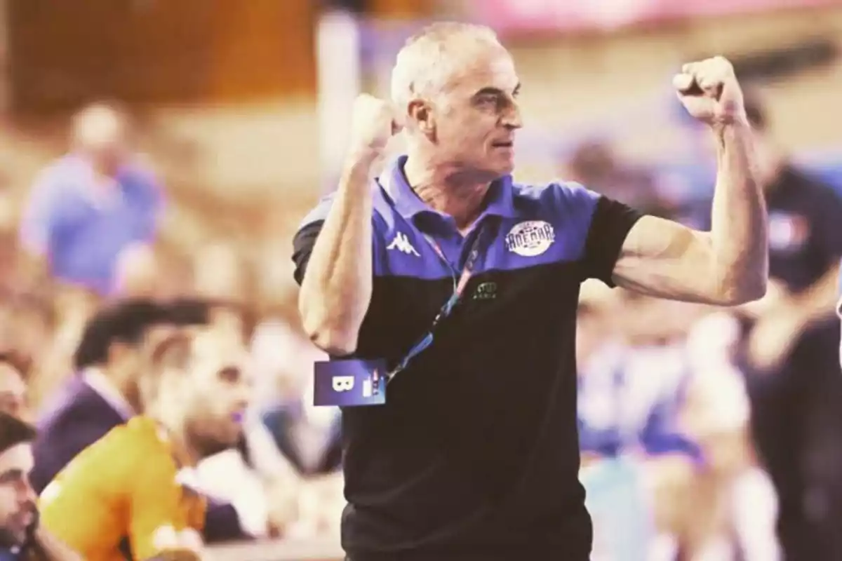 Entrenador de equipo deportivo celebrando con los brazos en alto durante un partido Entrenador de equipo deportivo celebrando con los brazos en alto durante un partido