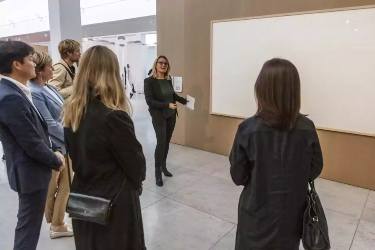 Un grupo de personas observando una presentación en una galería de arte.