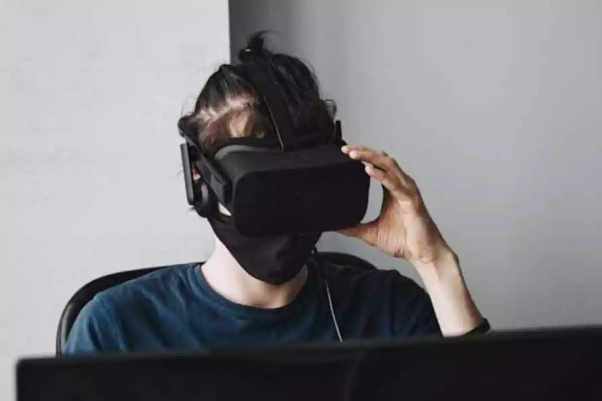 Persona usando un visor de realidad virtual y una mascarilla negra.