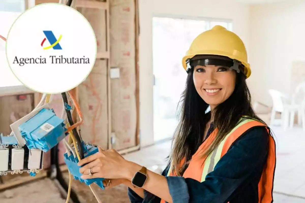 Una mujer con casco y chaleco de seguridad trabajando en una instalación eléctrica, con el logo de la Agencia Tributaria en la esquina.