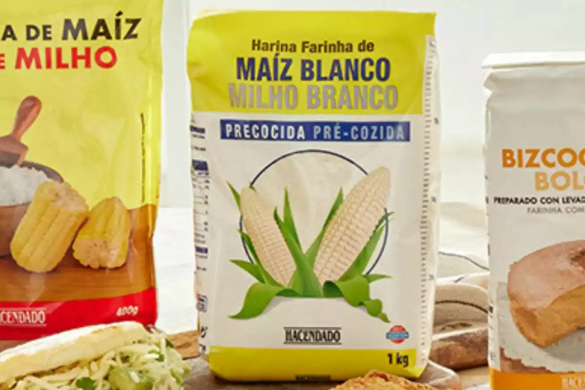 Tres paquetes de productos alimenticios, uno de harina de maíz amarillo, otro de harina de maíz blanco precocida y un tercero de mezcla para bizcocho. Tres paquetes de productos alimenticios, uno de harina de maíz amarillo, otro de harina de maíz blanco precocida y un tercero de mezcla para bizcocho.
