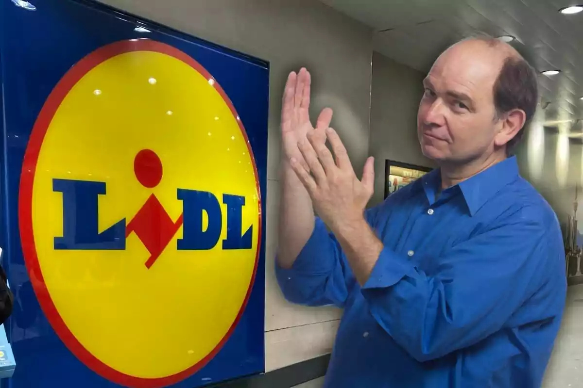 Un hombre con camisa azul aplaudiendo frente a un cartel de Lidl en un entorno interior.