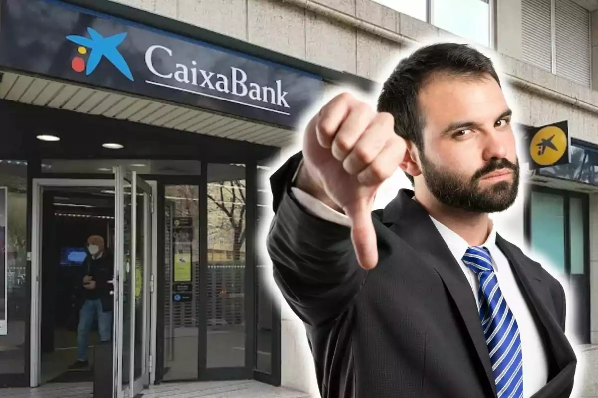 Un hombre con traje y corbata azul haciendo un gesto de desaprobación con el pulgar hacia abajo frente a una sucursal de CaixaBank.