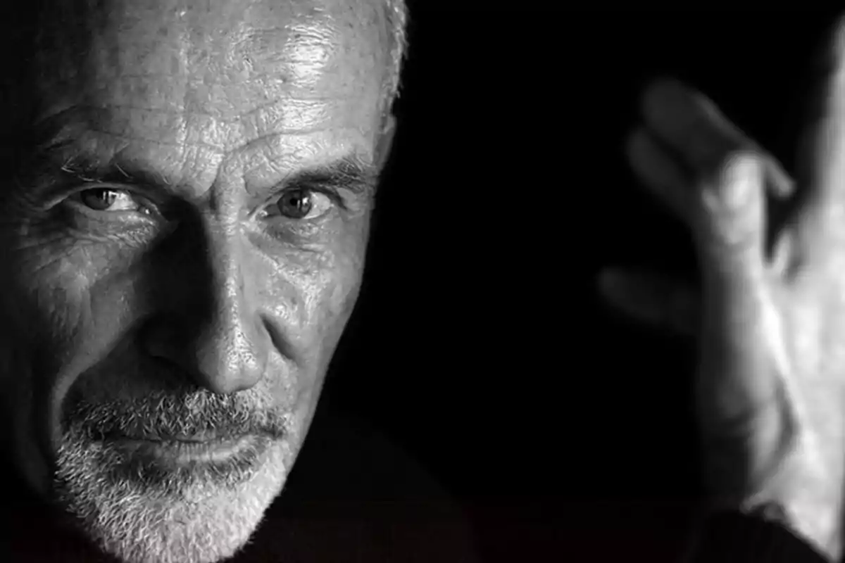 Un hombre mayor con barba y expresión seria en una fotografía en blanco y negro.