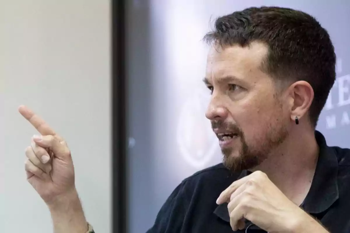 Un hombre con barba y cabello corto está señalando con el dedo mientras habla.