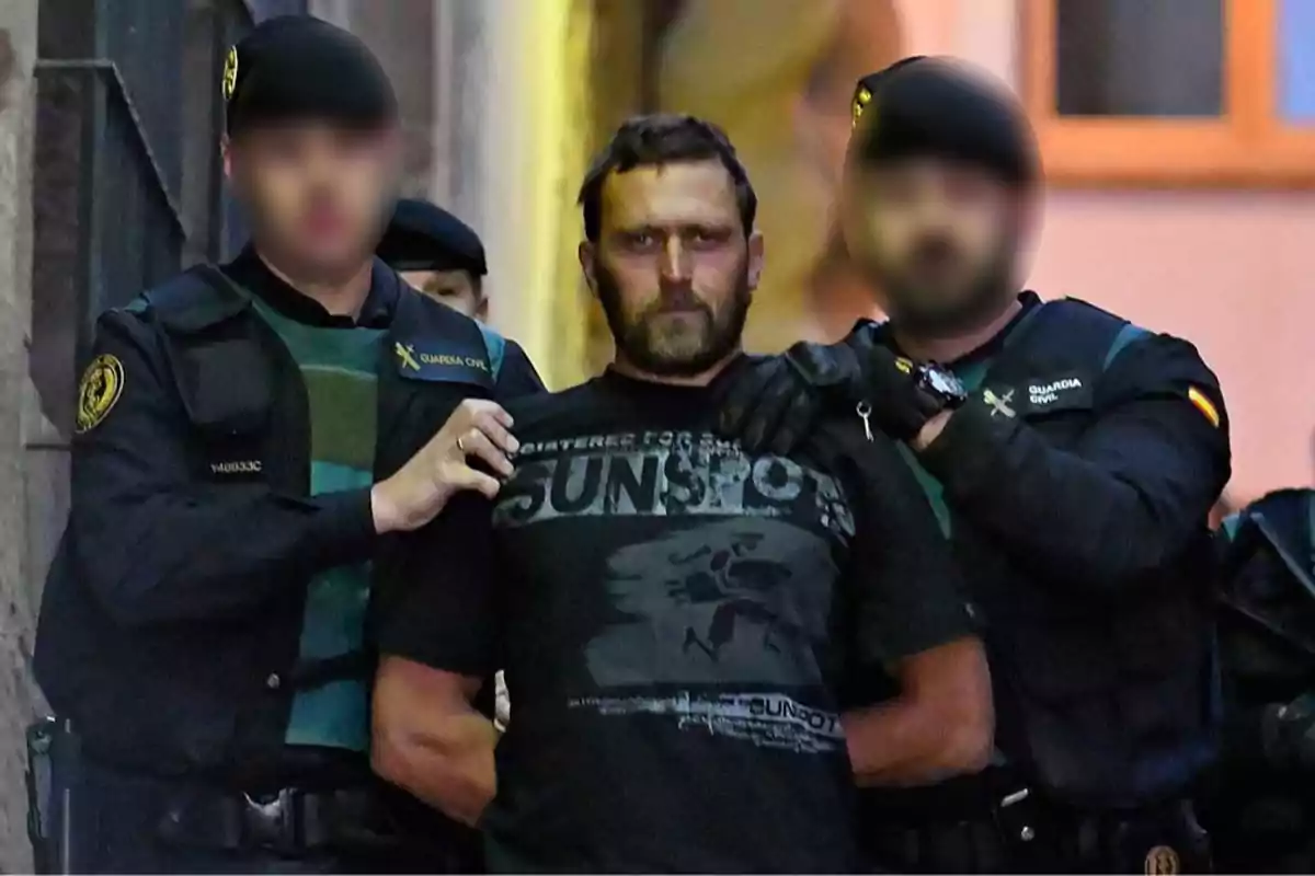 Un hombre es escoltado por dos agentes de la Guardia Civil en un entorno urbano.