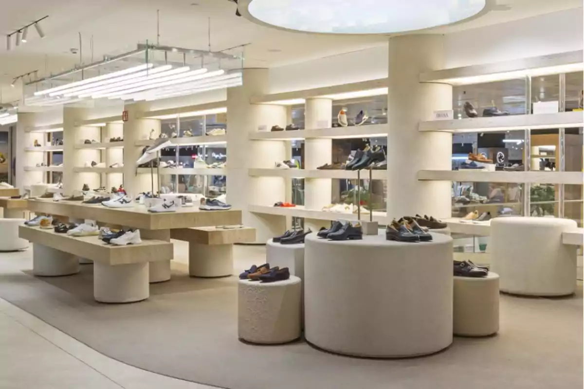 Tienda moderna de calzado con estanterías y mesas exhibiendo diferentes tipos de zapatos en un ambiente bien iluminado Tienda moderna de calzado con estanterías y mesas exhibiendo diferentes tipos de zapatos en un ambiente bien iluminado