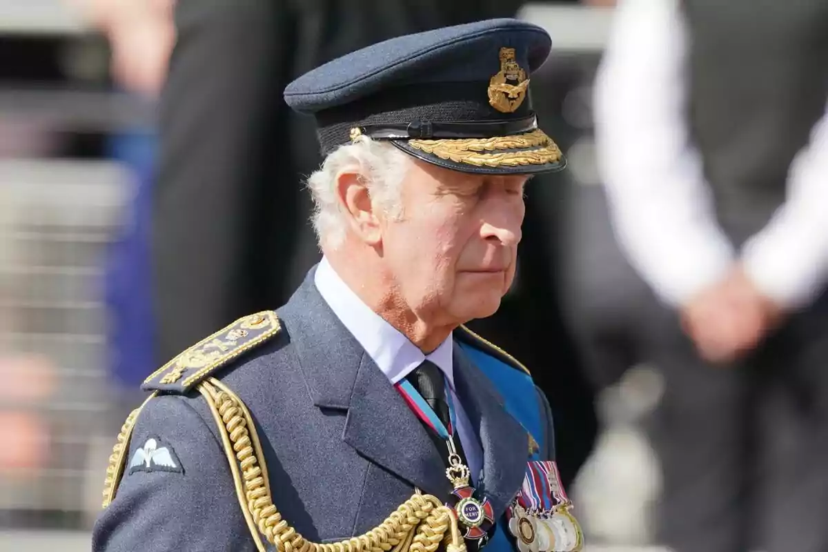 Un hombre con uniforme militar azul y gorra decorada con medallas y cordones dorados. Un hombre con uniforme militar azul y gorra decorada con medallas y cordones dorados.