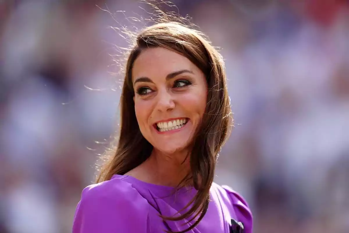 Mujer joven de cabello castaño largo sonriendo y usando un vestido morado con fondo desenfocado Mujer joven de cabello castaño largo sonriendo y usando un vestido morado con fondo desenfocado