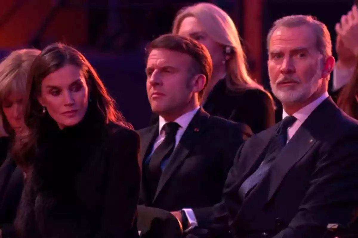 Los reyes Felipe VI y Letizia elegantemente vestidos están sentados en un evento formal, observando atentamente lo que sucede frente a ellos. Los reyes Felipe VI y Letizia elegantemente vestidos están sentados en un evento formal, observando atentamente lo que sucede frente a ellos.
