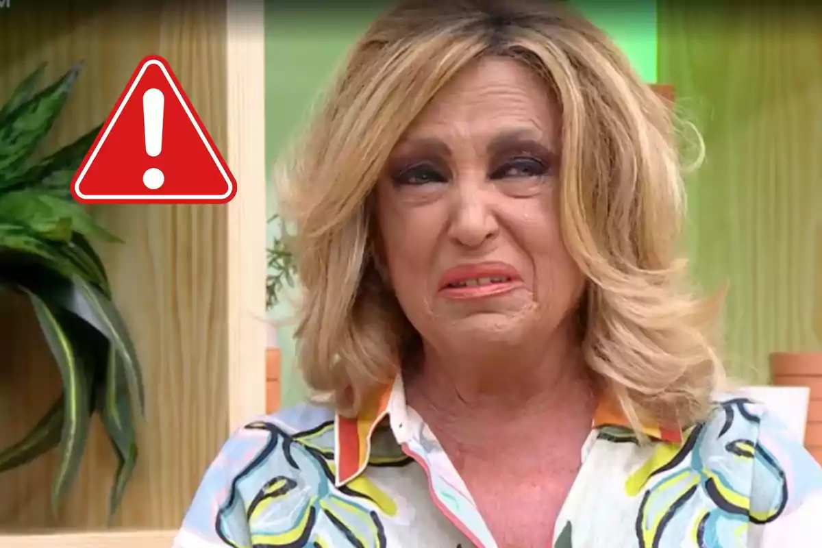 Lydia Lozano rubia con expresión de disgusto o tristeza y un símbolo de advertencia en el fondo