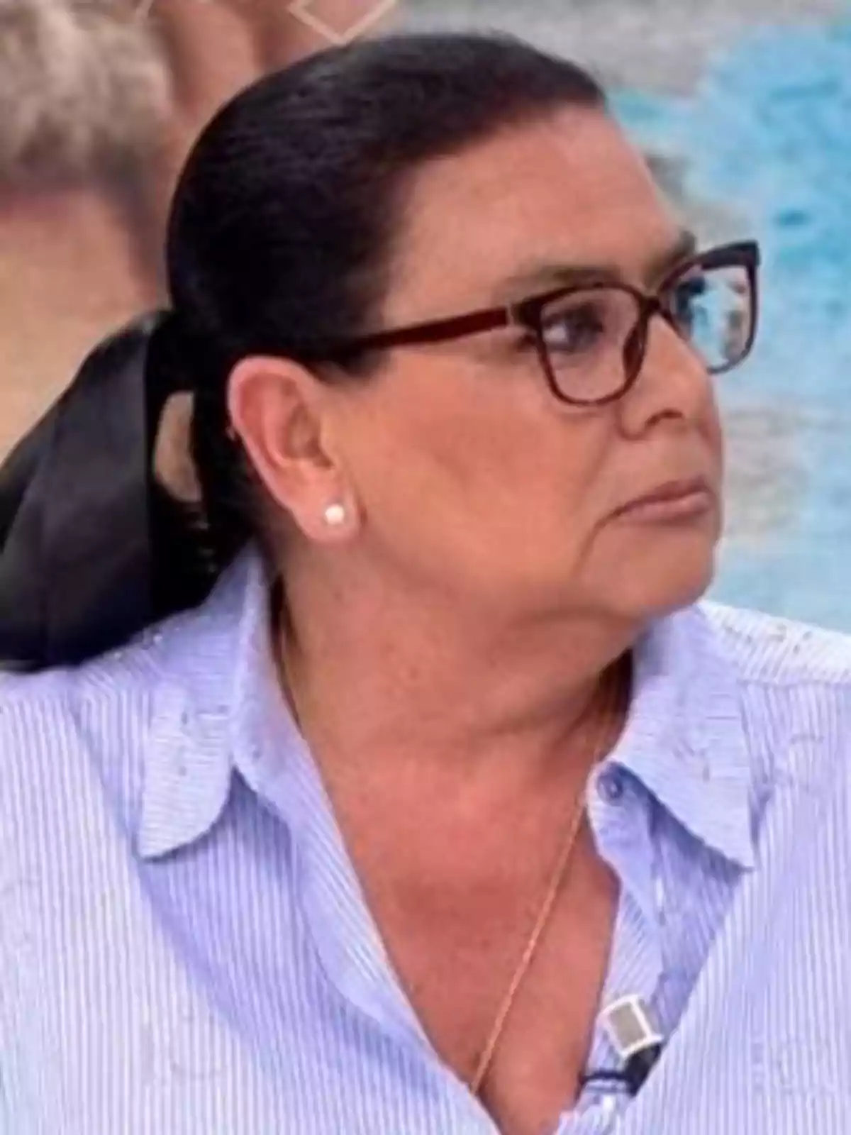 María del Monte con gafas y cabello recogido, vistiendo una camisa azul a rayas. María del Monte con gafas y cabello recogido, vistiendo una camisa azul a rayas.