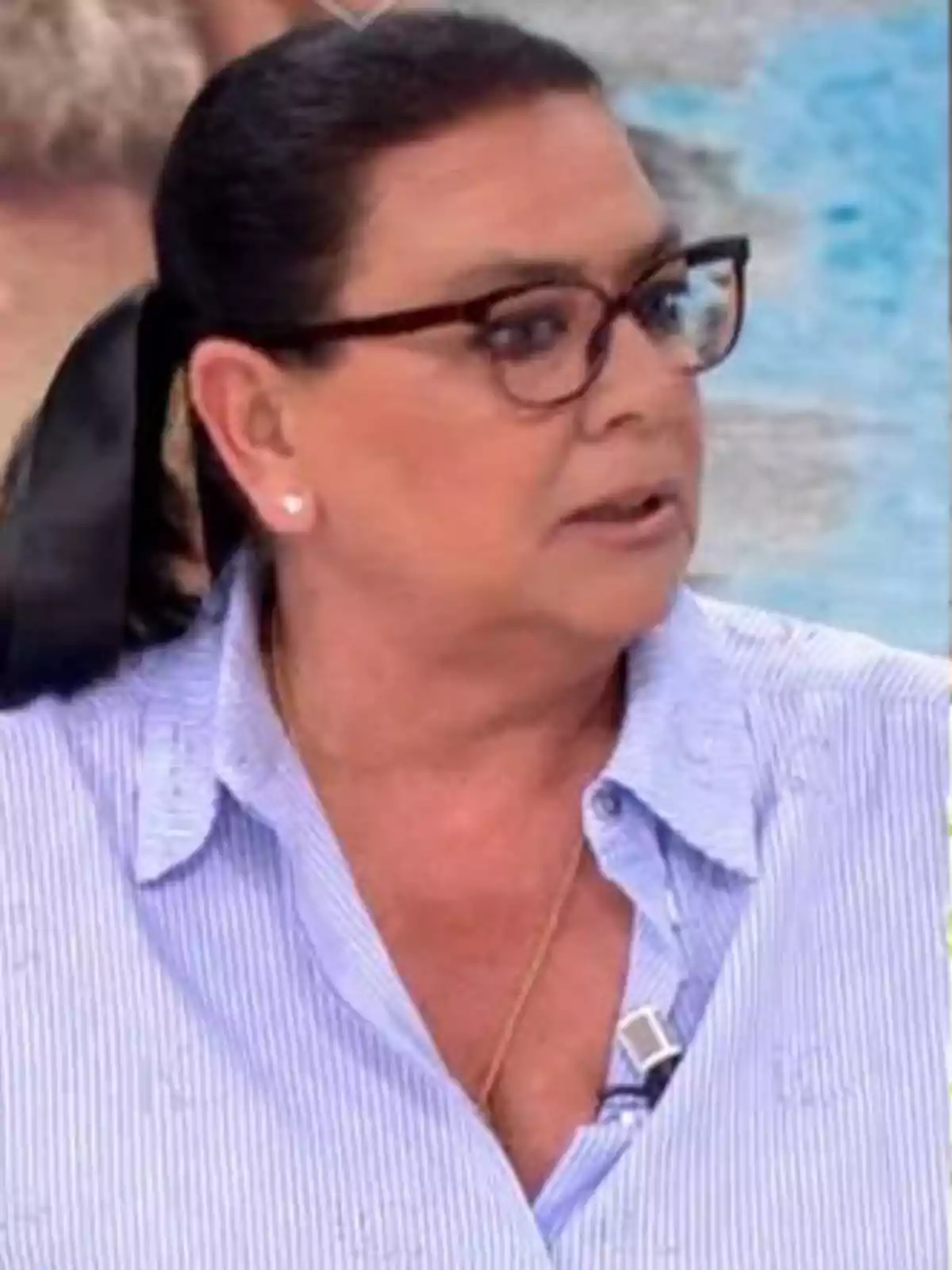 María del Monte con gafas y cabello recogido lleva una camisa de rayas azules y un micrófono de solapa. María del Monte con gafas y cabello recogido lleva una camisa de rayas azules y un micrófono de solapa.