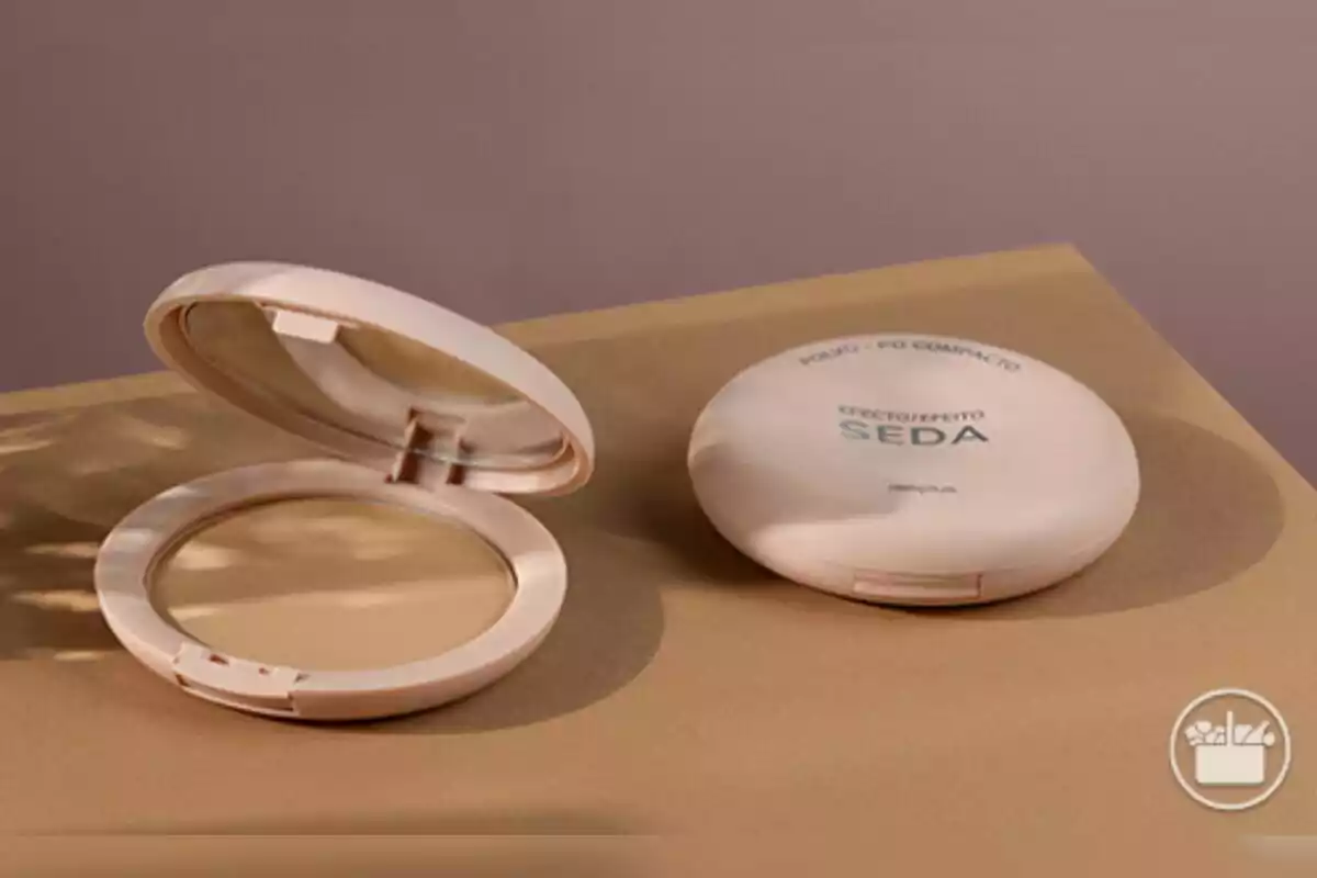 Polvo compacto en estuche abierto y cerrado sobre una superficie beige, el cual se vende en Mercadona. Polvo compacto en estuche abierto y cerrado sobre una superficie beige, el cual se vende en Mercadona.