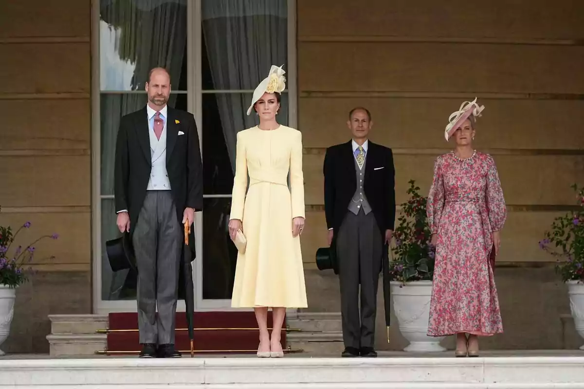 Un grupo de personas elegantemente vestidas posando en una escalera frente a un edificio con grandes ventanas y macetas con flores. Un grupo de personas elegantemente vestidas posando en una escalera frente a un edificio con grandes ventanas y macetas con flores.