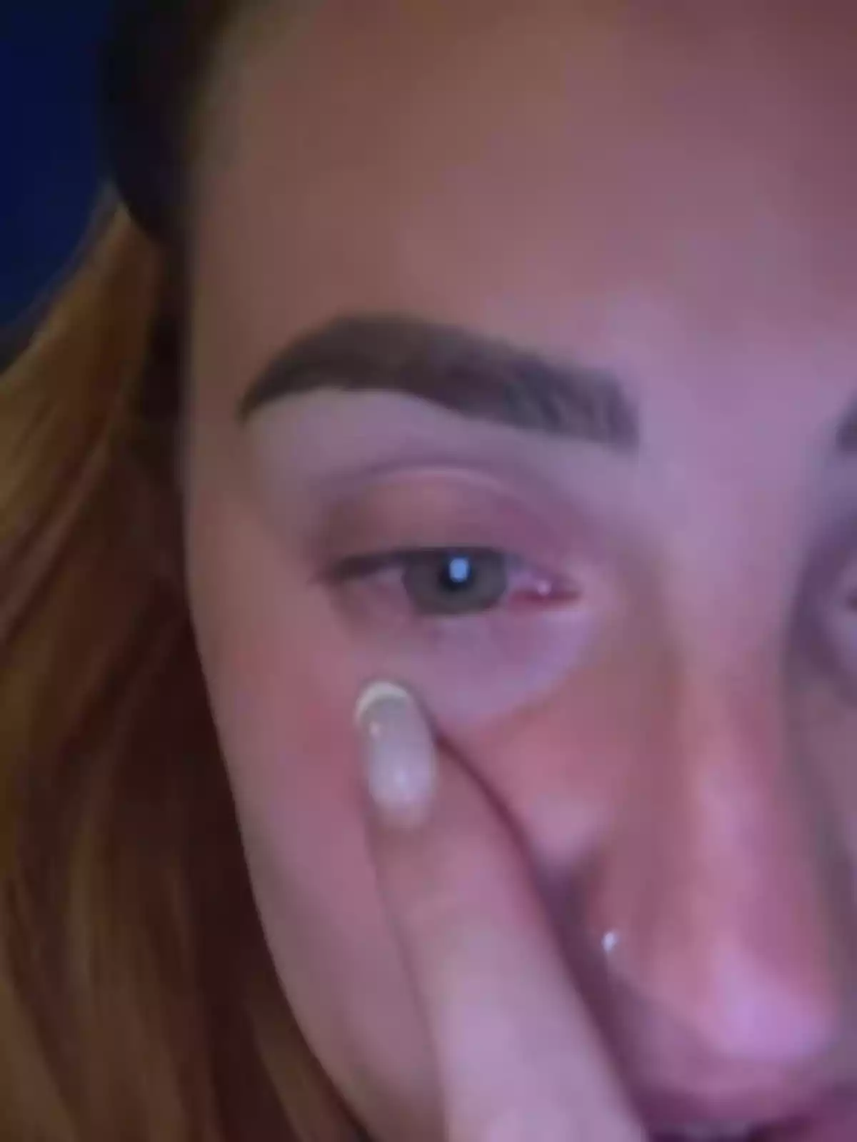 Rocío Flores con el cabello castaño claro se toca el rostro cerca del ojo, mostrando una expresión seria. Rocío Flores con el cabello castaño claro se toca el rostro cerca del ojo, mostrando una expresión seria.