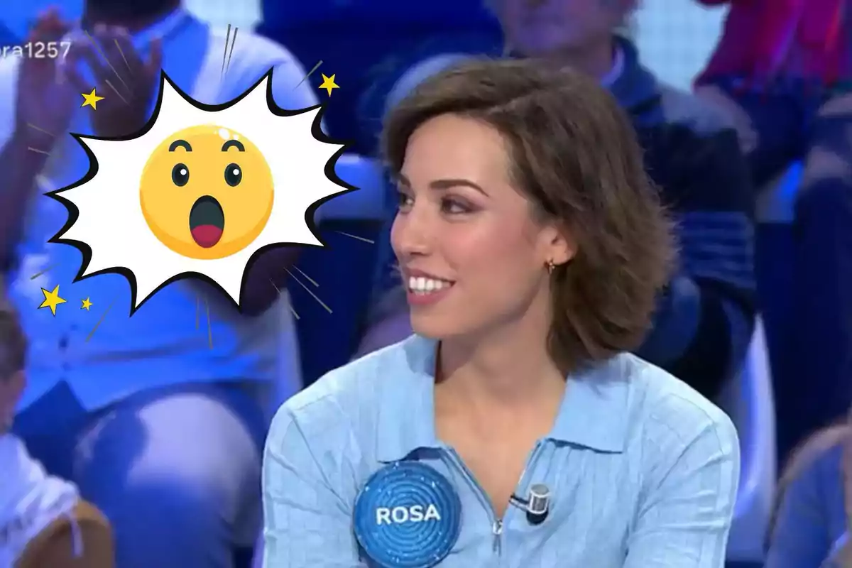 Rosa sonriente con una etiqueta que dice "ROSA" en un programa de televisión, con un emoji sorprendido superpuesto.