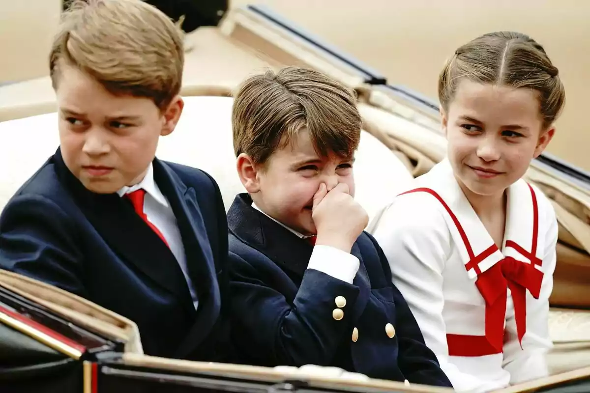 Tres niños vestidos formalmente están sentados en un carruaje, uno de ellos se tapa la nariz mientras los otros dos miran en direcciones opuestas. Tres niños vestidos formalmente están sentados en un carruaje, uno de ellos se tapa la nariz mientras los otros dos miran en direcciones opuestas.