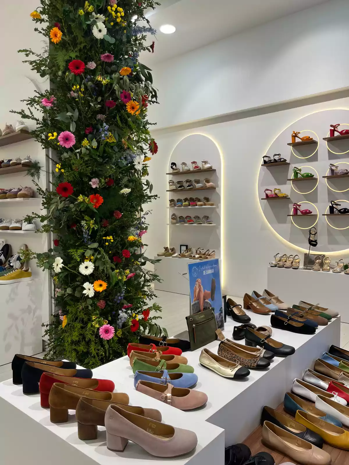 Una tienda de zapatos con una decoración floral vibrante y estantes llenos de calzado colorido. Una tienda de zapatos con una decoración floral vibrante y estantes llenos de calzado colorido.