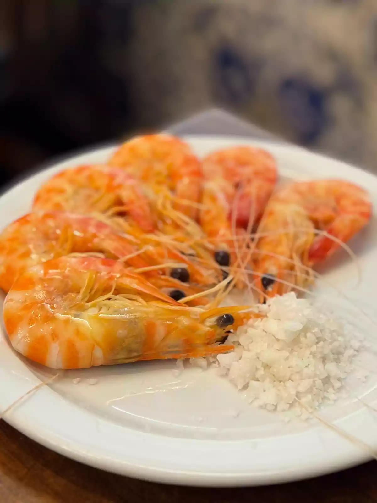 Un plato de camarones cocidos con sal gruesa.