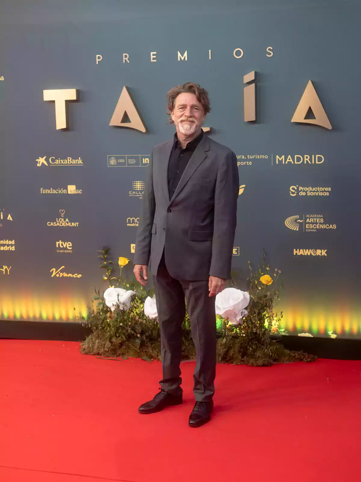 Hombre con traje gris posando en la alfombra roja de los Premios Talía en Madrid. Hombre con traje gris posando en la alfombra roja de los Premios Talía en Madrid.