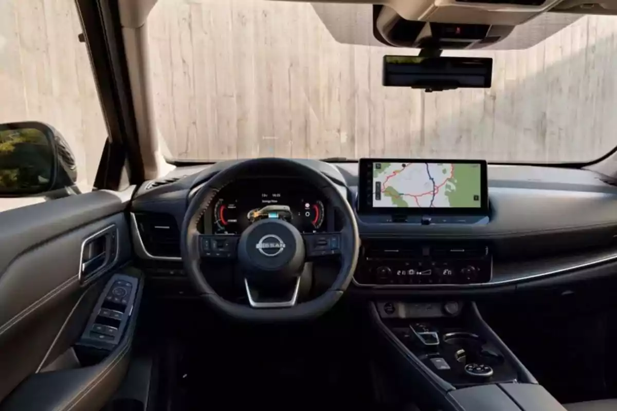 Interior de un automóvil Nissan con volante, pantalla de navegación y controles en el tablero.