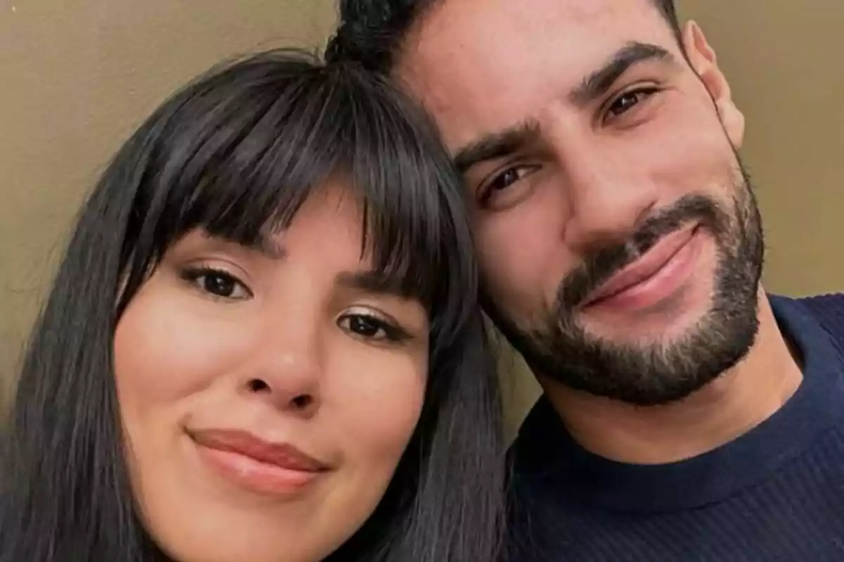 Una pareja sonriente, formada por Asraf Beno e Isa Pantoja, posando para una selfie.