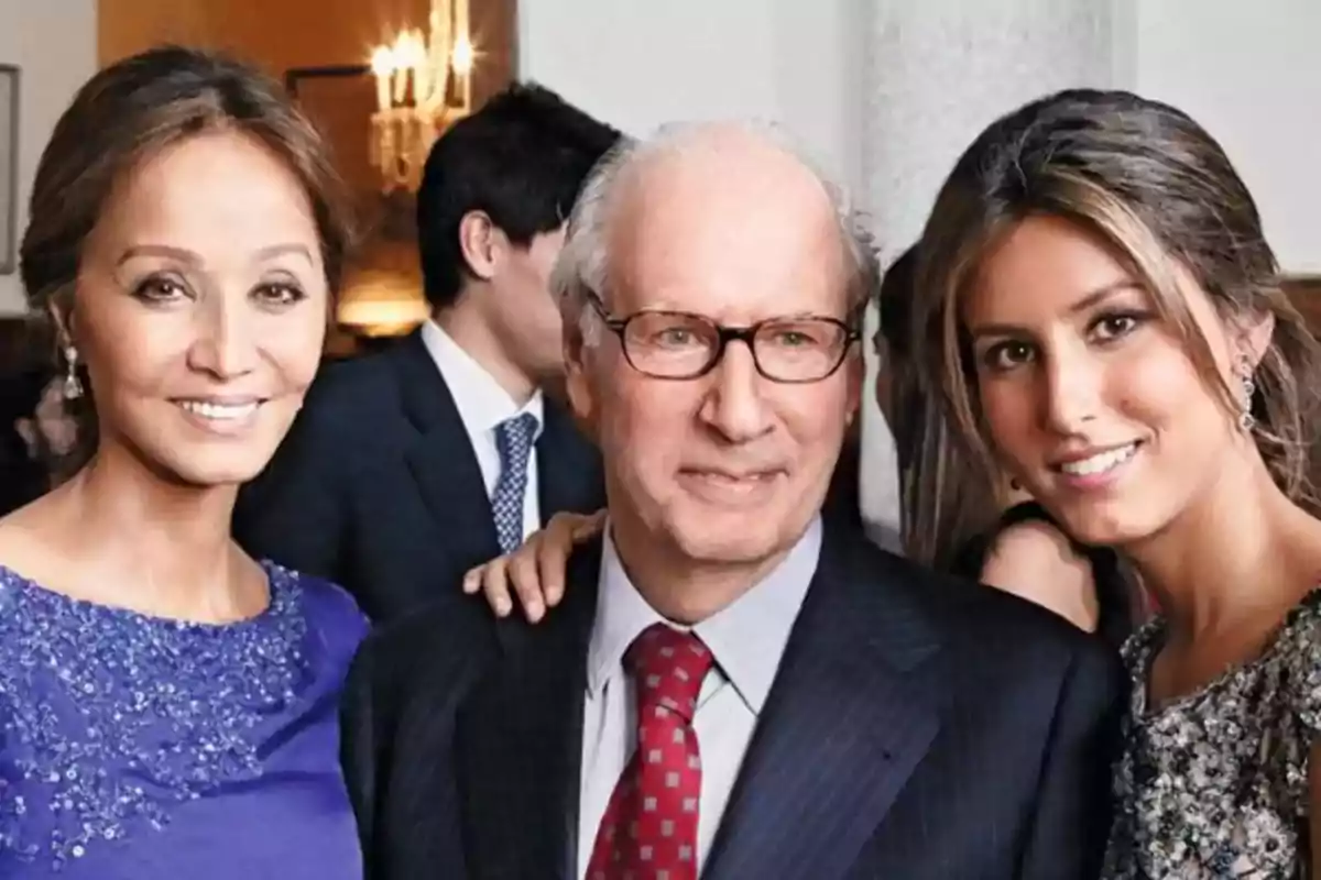 Tres personas posando juntas en un evento formal.