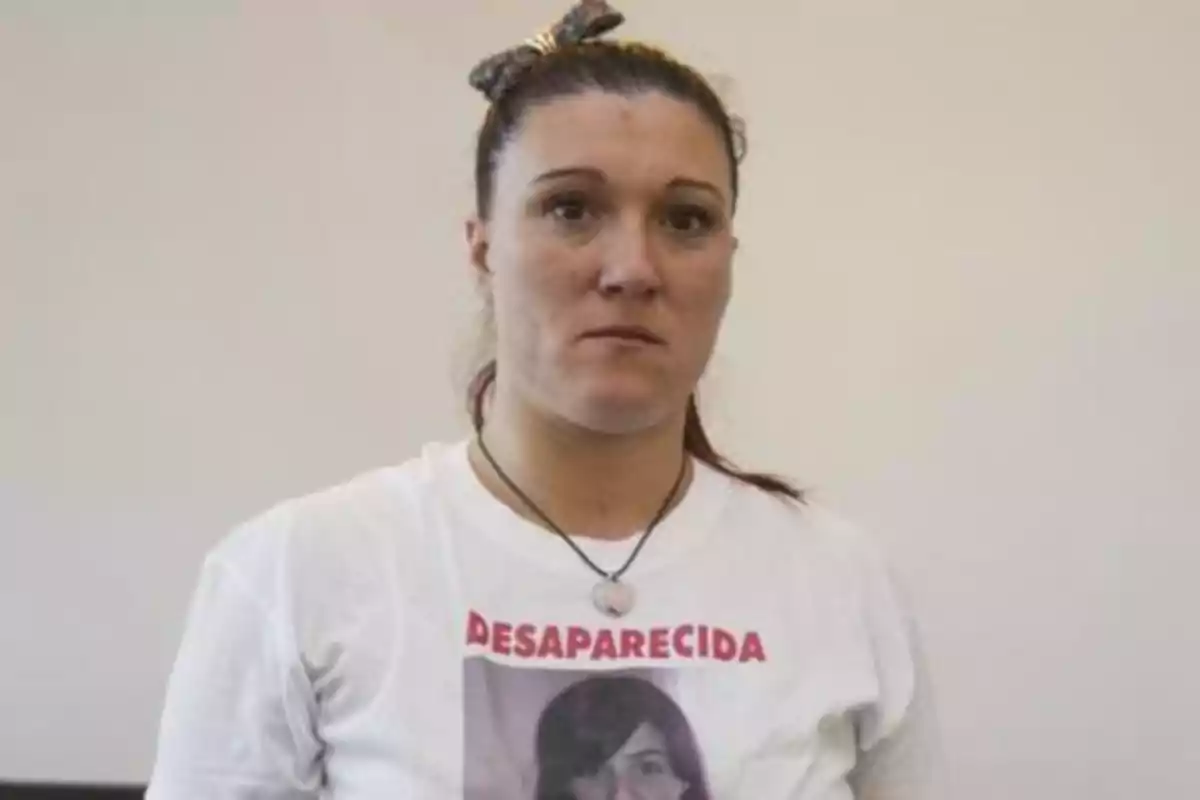 Mujer con camiseta blanca que tiene una foto y la palabra 