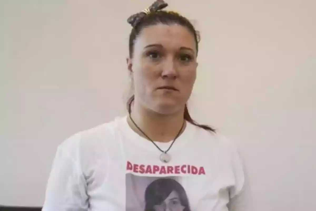Mujer de cabello recogido con moño, usando una camiseta blanca con la palabra Mujer de cabello recogido con moño, usando una camiseta blanca con la palabra
