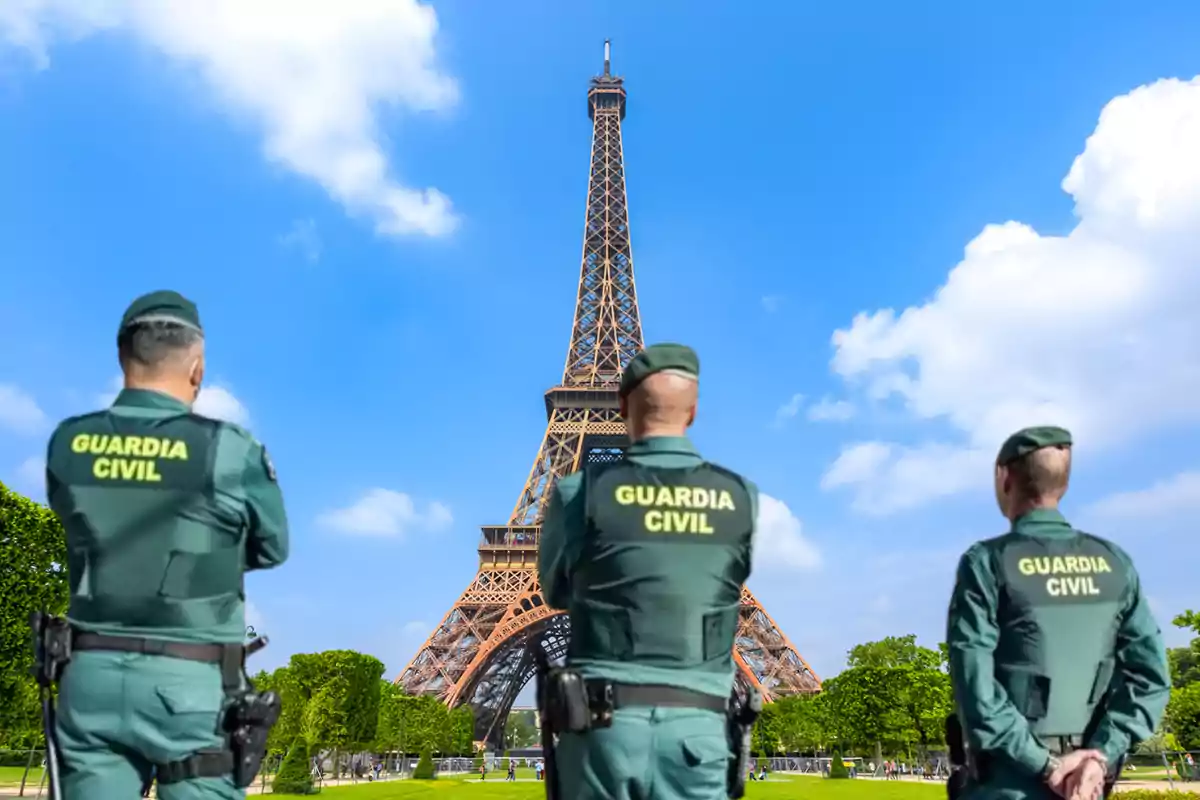 Tres agentes de la Guardia Civil de espaldas frente a la Torre Eiffel en París.