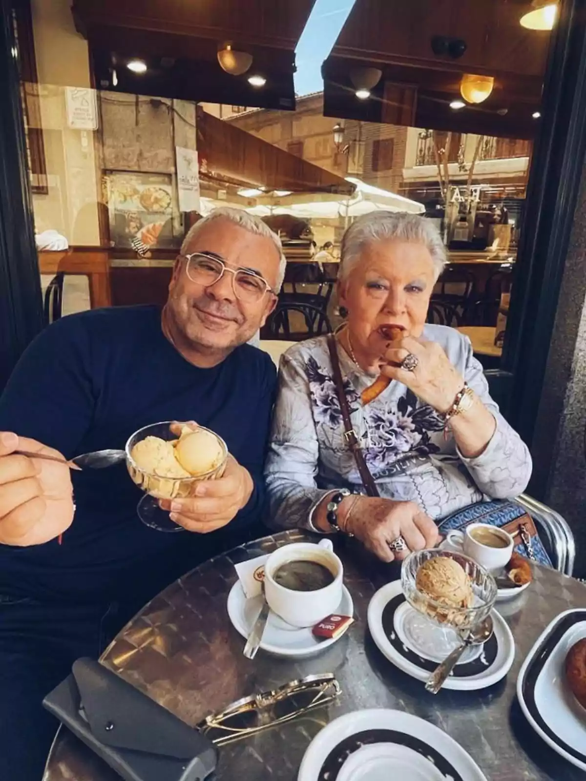 Jorge Javier Vázquez y María Morales sentados en una mesa de café al aire libre, disfrutando de helado y café. Post de Jorge Javier en Instagram el 8 de abril de 2023