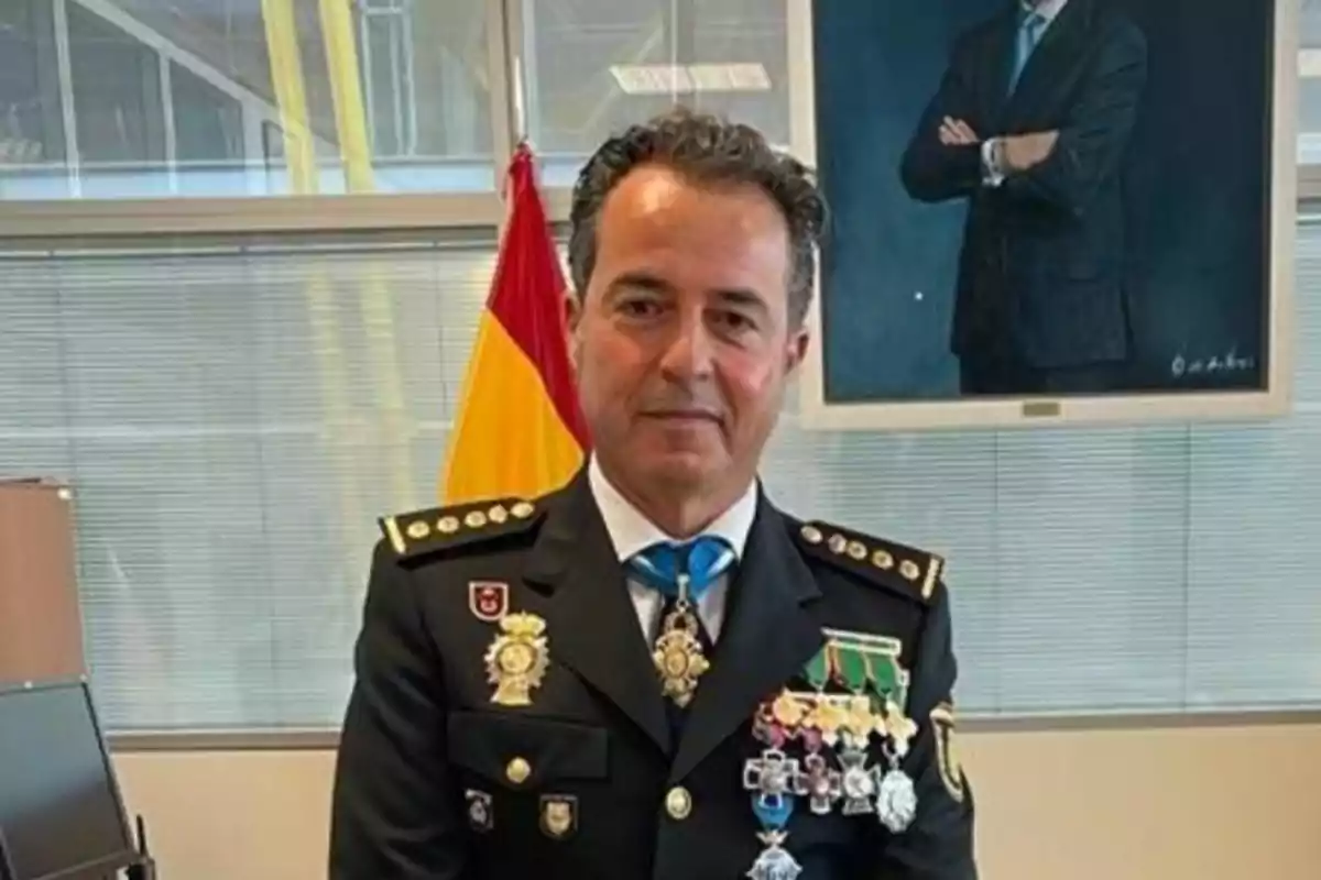 Un hombre en uniforme militar con varias medallas y una bandera en el fondo.